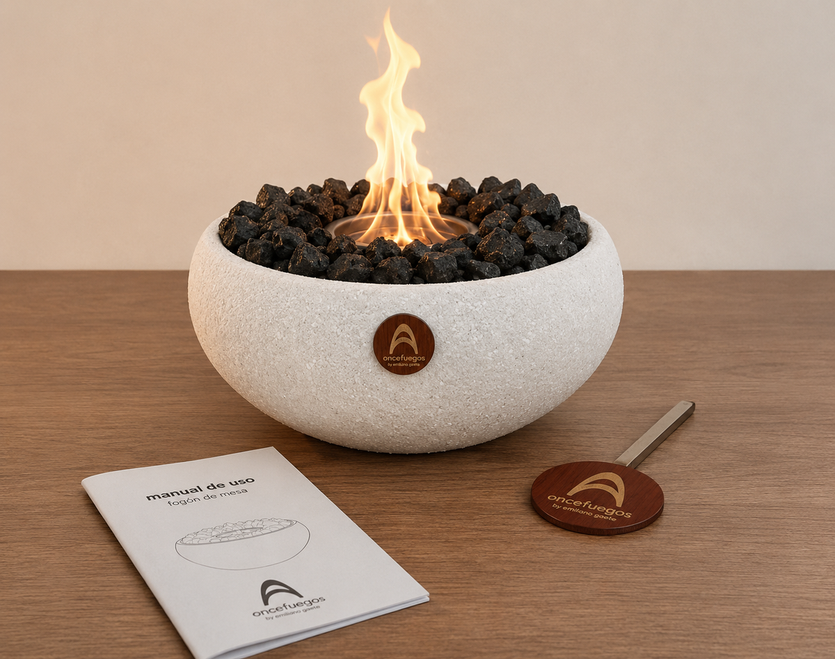 Elquí Grande Obsidiana encendido sobre una mesa de madera junto al manual de uso y el ahogador de llama